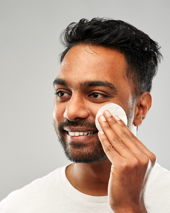 asian male skin model wiping face with Biojuve pad
